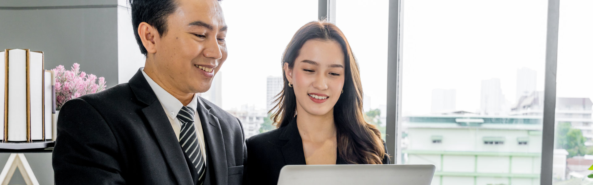 man and woman looking at the laptop